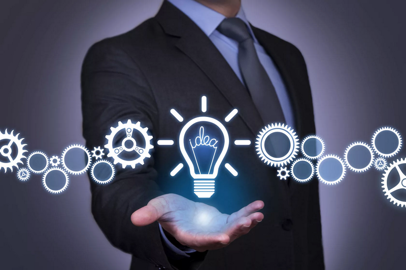 A businessman holding a glowing light bulb labeled idea, with gears and cogs floating along his extended arm, symbolizing innovation